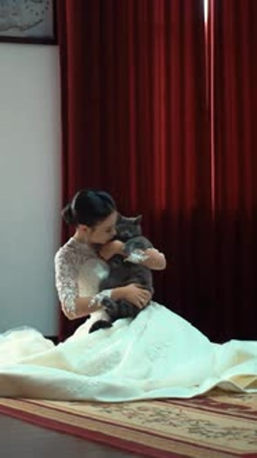 Woman in Wedding Dress Holding a Cat