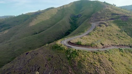 Drone Flying Toward Traveler on Curvy Mountain Road