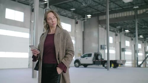 Confident Woman in Warehouse Texting