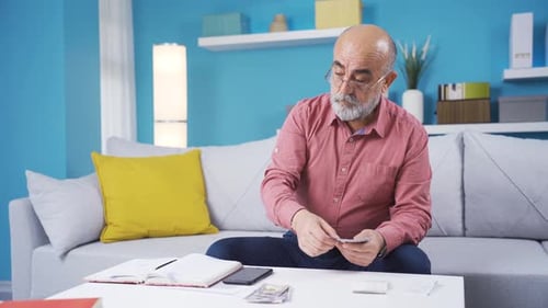 Senior Man Counting Cash at Home