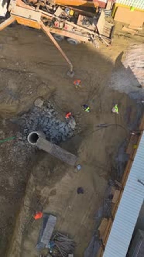 Die Arbeiten am vertikalen Videofundament beginnen mit Bauarbeitern und schweren Maschinen auf einer neuen Baustelle
