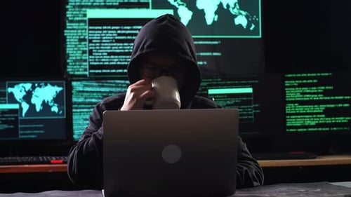Un hacker asiatique dans un quartier boit du café tout en travaillant sur un ordinateur portable avec des cartes et des données