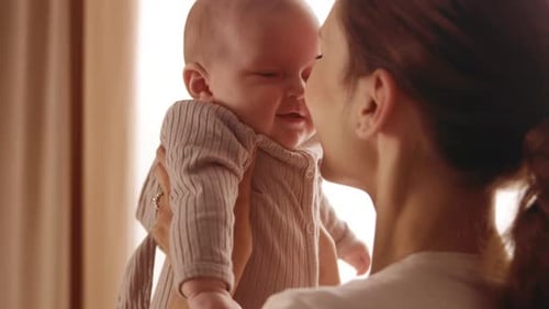 Loving Mother Holds Adorable Baby Up Close