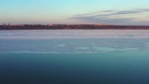Acercándose a la costa con una pequeña ciudad al atardecer Cambiando la estructura del hielo marino derritiéndose el hielo con