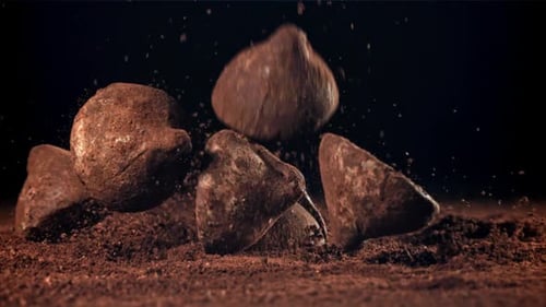 Chocolate Truffles Falling onto Cocoa Powder Surface