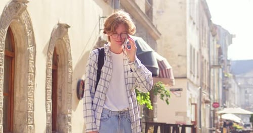 Goodlooking Caucasian Man Walking in City and Calling Girlfriend Outdoors Young Male Student Wearing