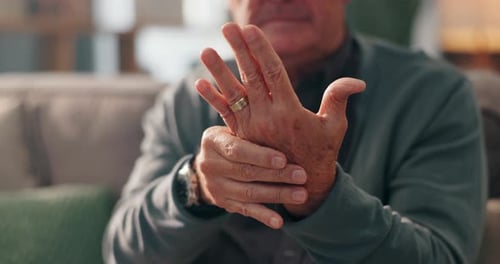 Senior Man Massaging Aching Hand Joints at Home