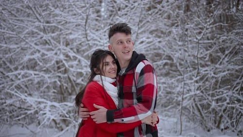 Ein Mann umarmt seine Freundin in einem frostigen kalten Winter