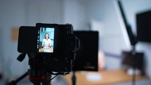 Working professional camera with a woman at display. Close up. Blog content creation.