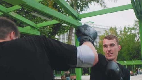 Outdoor Boxing Practice Two Men Engaging in Training Boxers Practicing on Urban Park Equipment