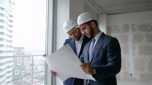 Men Reviewing Blueprints at Construction Site