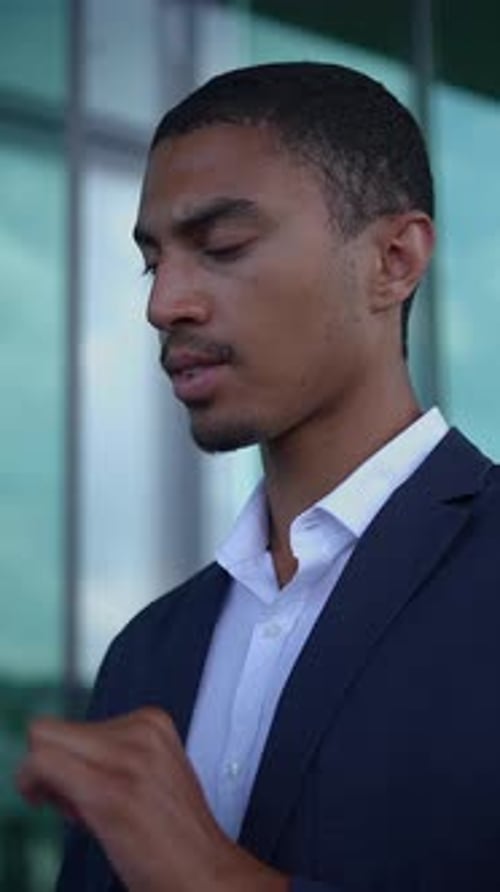 Man in Suit Uses Tablet Outside Office Building