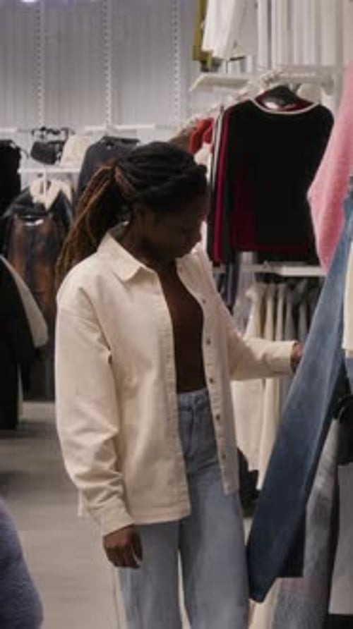 Vertical of Woman Looking through Clothes in Store