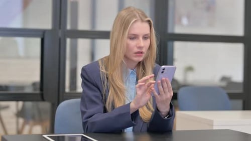 Worried Woman Uses Phone in Office Setting
