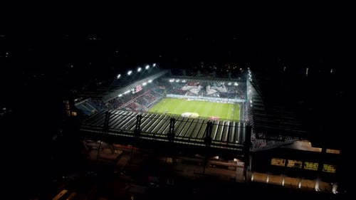 Aerial shot of football stadium during the match, fans and floodlights