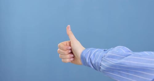Hand Giving Thumbs Up on Blue Background