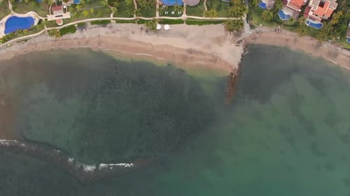 AERIAL: Beach from above with waves and pools.