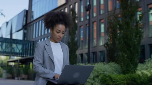Woman Working on Laptop in Urban Setting