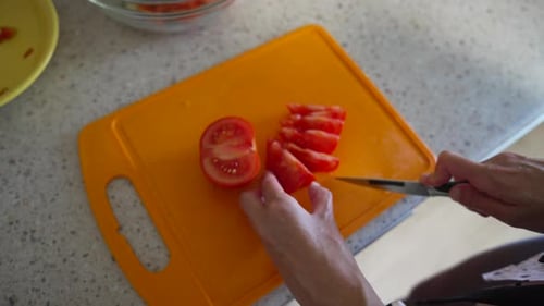 Close Up of Cutting Tomato on Orange Board