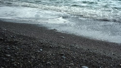 Ruhige Wellen am Ufer eines felsigen Strandes