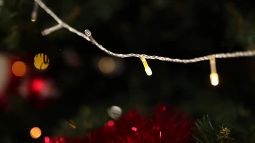 Christmas decorated tree close up garland lights hanging in a tree Merry Christmas