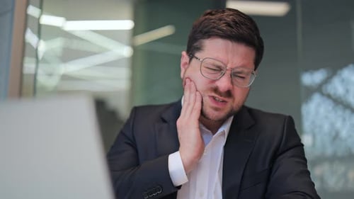 Businessman Suffering From Severe Toothache In Office