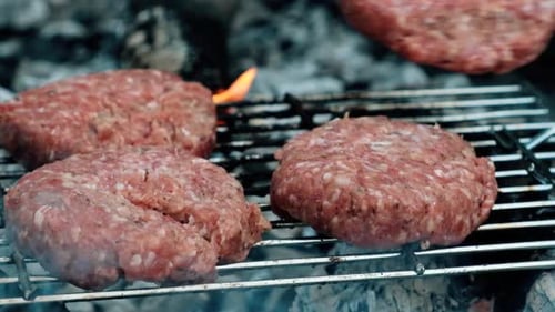 Fleischbällchen werden gegrillt und am Lagerfeuer in freier Wildbahn auf dem Grillrost hinzugefügt