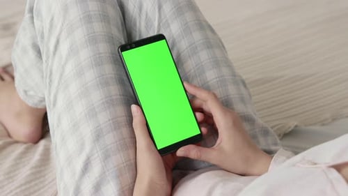 Woman Holds Phone With Chroma Key Screen Indoors