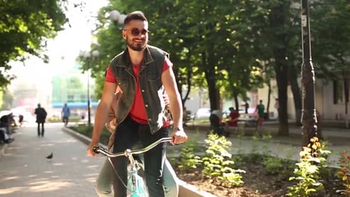 Jovem casal andando de bicicleta juntos no parque Namorado romântico andando de bicicleta com namorada feliz