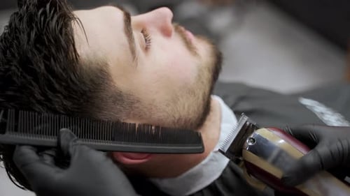 Barber Giving Haircut to Young Adult Man