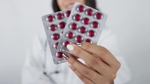 Close up of female doctor offering pills for treatment