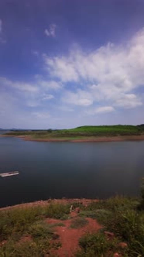 The camera shows a wide view of Ray Lake in Vietnam. There is water, land, and a few clouds in the