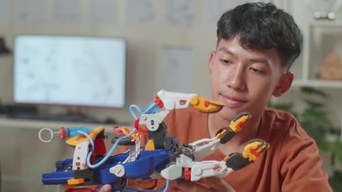 Close Up Of Asian Boy With A Laptop Checking A Cyborg Hand At Home