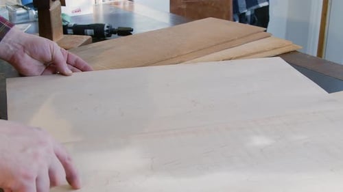 Luthier examina piezas de madera de abeto para construir una guitarra acústica en el taller