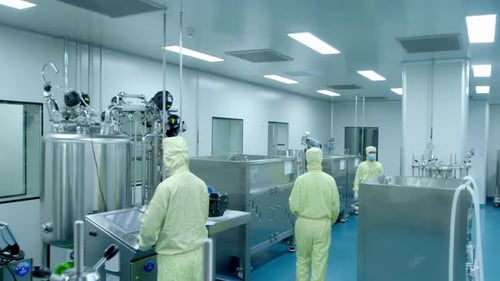 Des scientifiques ou des techniciens avancés en uniforme stérile vérifient les données sur un ordinateur personnel