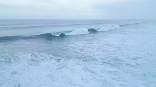 Majestic Atlantic wave rolling to shore near Aljezur, Portugal, captured from above