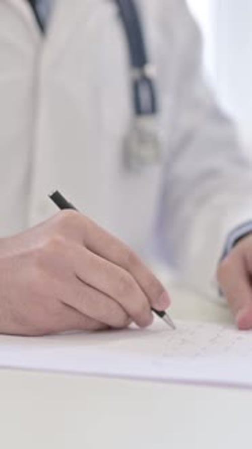 Doctor Writing Prescription in Clinic Office