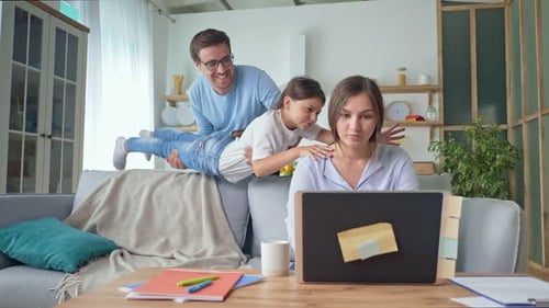 A Parent Working From Home Mom is Stressed From Working Remotely at Home While Daughter and Father