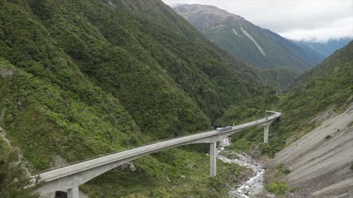 Large truck driving over Otira Viaduct bridge with traffic stuck behind in Arthurs Pass New Zealand