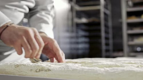 Caucasian Male Hands Cutting Duff with Razor Working in Bakery Indoors Baker Job Concept Man