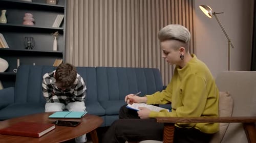 Boy Speaks to Counselor During Therapy Session