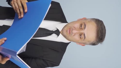 Man in Suit Holds Blue Binder Thumbs Up