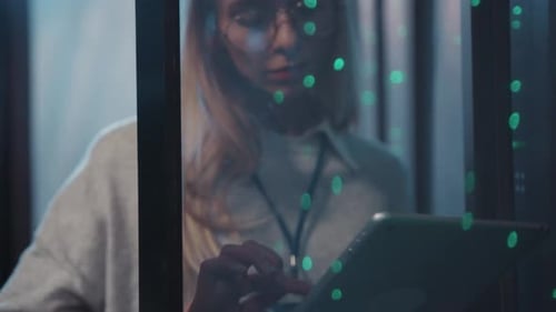 Eine Frau mit Brille am Fenster benutzt ein Tablet, das Intellekt und Technologie vereint