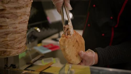 Chef making pita with roasted chicken meat on table - summer food market. Cooking, gastronomy