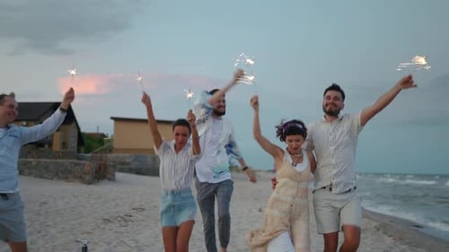 Friends Celebrate with Sparklers on Beach at Dusk
