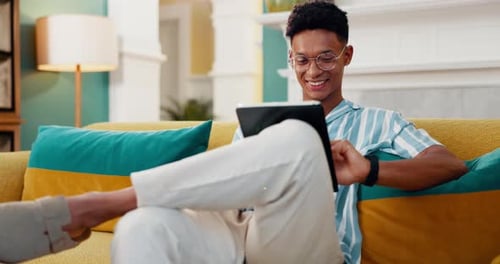 Search, smile and tablet with man on sofa for online reading, communication and social media post