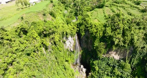 Tropical Waterfall Cascading Through Lush Green Environment