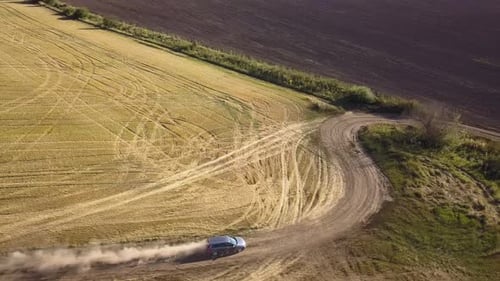 Top Down Aerial View of Fast Driving Car on Dirt Road Leaving Cloud of Dust Behind