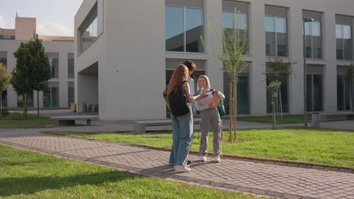 University Students Collaborating on Project Outside Modern Campus Building