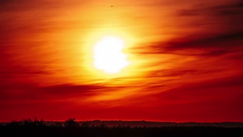 Zeitraffer eines Dramatisch Sonnenuntergangs am orangefarbenen Himmel durch Wolken